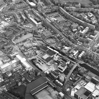 Oblique aerial view centred on the brewery with the canal, canal basin and canal bridge adjacent, taken from the WNW.