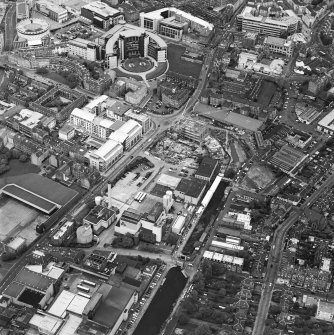 Oblique aerial view centred on the brewery with the canal, canal basin and canal bridge adjacent, taken from the SW.