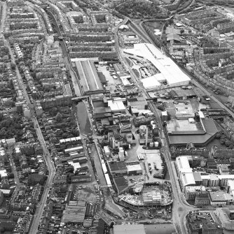Oblique aerial view centred on the brewery with the leisure centre and cinema, canal, canal basin and canal bridge adjacent, taken from the ENE.