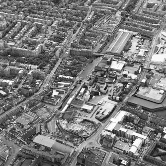 Oblique aerial view centred on the brewery with the canal, canal basin and canal bridge adjacent, taken from the NNE.