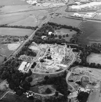 Oblique aerial view centred on the Royal Bank of Scotland headquarters under construction with the hospital and house and the excavation adjacent, taken from the SW.