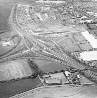 Oblique aerial view centred on the motorway interchange with the industrial estate adjacent, taken from the S.