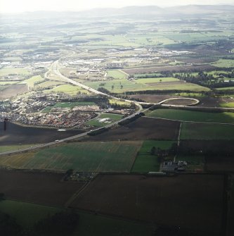 General oblique aerial view looking across the town, farmsteading and motorway interchange towards Newbridge and the railway viaduct, taken from the N.