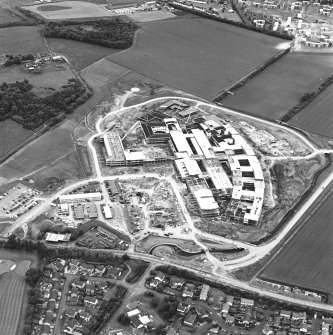 Oblique aerial view centred on the Royal Infirmary of Edinburgh at Little France under construction, taken from the SW.