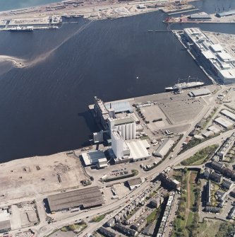 Oblique aerial view centred on the flour mills with the docks adjacent, taken from the SW.