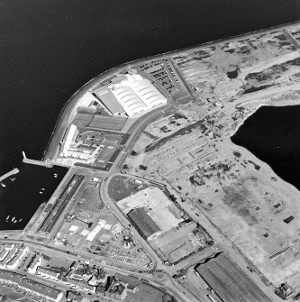 Oblique aerial view centred on the breakwater with the docks, harbour and fishmarket adjacent, taken from the SSE.
