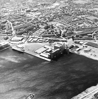 Oblique aerial view centred on the flour mills with the docks adjacent, taken from the N.