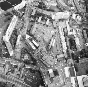 Oblique aerial view centred on the excavation with the warehouses and offices adjacent, taken from the SW.