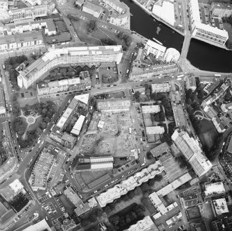 Oblique aerial view centred on the excavation with the warehouses and offices adjacent, taken from the SE.