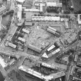 Oblique aerial view centred on the excavation with the warehouses and offices adjacent, taken from the NW.