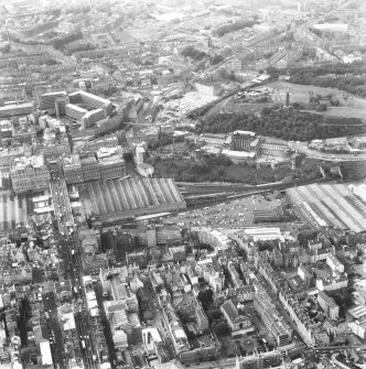 Oblique aerial view of centre of Edinburgh centred on St. Andrew's House, boiler house, and including St James' Centre and New Town at top of photograph, Royal High School to right, Cowgate at bottom and Waverley Station to left.
