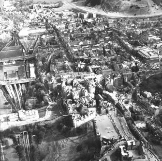 Oblique aerial view of centre of Edinburgh including Esplanade at The Castle in foreground, looking down High Street towards Holyrood Palace, with The Mound and the National Gallery for Scotland on left of photograph and Old College and The National Museum of Scotland on right