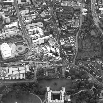 Oblique aerial view centred on the construction of the Scottish Parliament with exhibition centre adjacent, taken from the ENE.