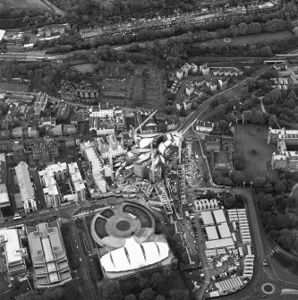 Oblique aerial view centred on the construction of the Scottish Parliament with exhibition centre adjacent, taken from the ESE.