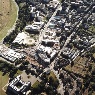 Oblique aerial view centred on the construction of the Scottish Parliament with the exhibition centre and palace adjacent, taken from the NE.