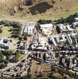 Oblique aerial view centred on the construction of the Scottish Parliament with the exhibition centre and palace adjacent, taken from the NW.