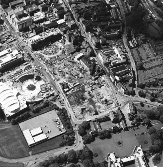 Oblique aerial view centred on the construction site, with exhibition centre and Queensbury House adjacent, taken from the SE.