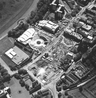 Oblique aerial view centred on the construction site, with exhibition centre and Queensbury House adjacent, taken from the NE.