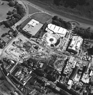 Oblique aerial view centred on the construction site, with exhibition centre and Queensbury House adjacent, taken from the N.