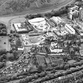 Oblique aerial view centred on the Scottish parliament under construction with `Our Dynamic Earth' and burial ground adjacent, taken from the NNW.
