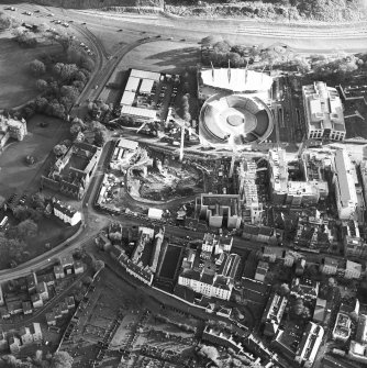 Oblique aerial view centred on the the Scottish Parliament under construction  with 'Our Dynamic Earth' and Queensberry House adjacent, taken from the NW.