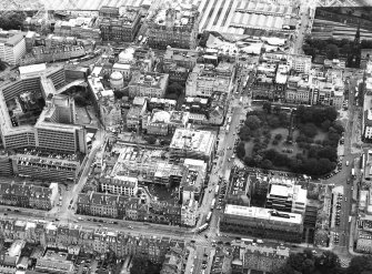 Oblique aerial view centred on the construction of the shop and the bus station with the bank adjacent, taken from the NNW.
