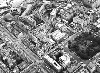 Oblique aerial view centred on the construction of the shop and the bus station with the bank adjacent, taken from the WNW.