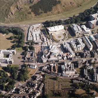 Oblique aerial view centred on the construction of the Scottish Parliament with the exhibition centre adjacent, taken from the NNW.