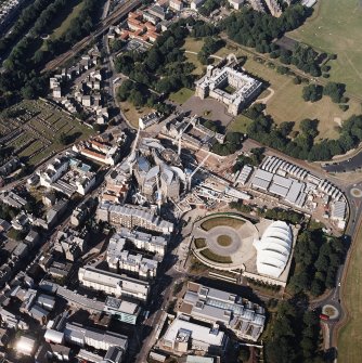 Oblique aerial view centred on the construction of the Scottish Parliament with the exhibition centre and palace adjacent, taken from the SW.