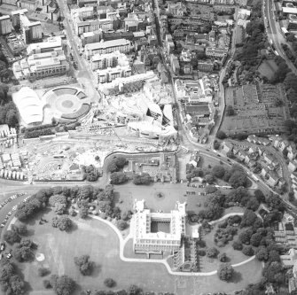 Oblique aerial view centred on the Scottish Parliament under construction with `Our Dynamic Earth¿ and the palace adjacent, taken from the ENE.