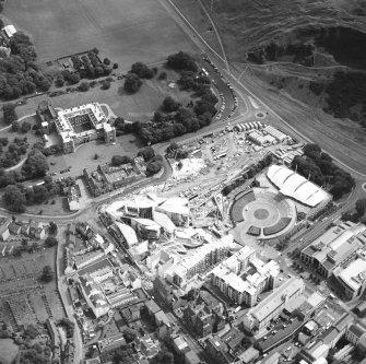 Oblique aerial view centred on the Scottish Parliament under construction with `Our Dynamic Earth¿ and the palace adjacent, taken from the W.