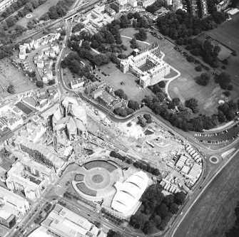 Oblique aerial view centred on the Scottish Parliament under construction with `Our Dynamic Earth¿ and the palace adjacent, taken from the SW.