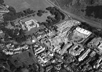 Oblique aerial view centred on the construction of the Scottish Parliament with the exhibition centre and palace adjacent, taken from the WNW.