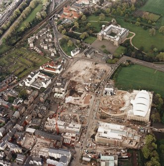 Oblique aerial view of Edinburgh centred on the construction of the Scottish Parliament with Holyrood Palace and 'Our Dynamic Earth' building adjacent, taken from the SW.