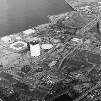 Oblique aerial view centred on the gasworks with the country house adjacent, taken from the SW.