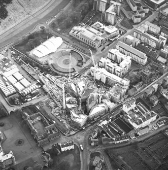 Oblique aerial view centred on the construction of the Scottish Parliament with exhibition centre adjacent, taken from the NNE.