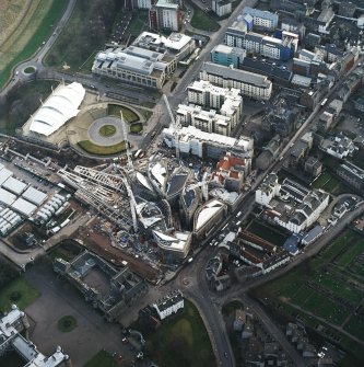 Oblique aerial view centred on the construction of the Scottish Parliament with exhibition centre adjacent, taken from the NE.
