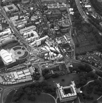 Oblique aerial view centred on the construction of the Scottish Parliament with the exhibition centre adjacent, taken from the E.