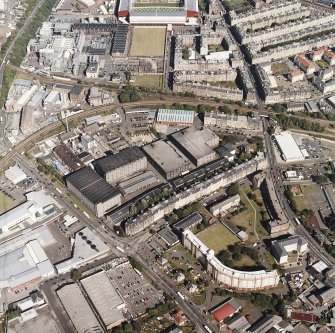 Oblique aerial view centred on the bonded warehouse with the park and bowling green and the football stadium adjacent, taken from the W.