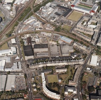 Oblique aerial view centred on the bonded warehouse with the park and bowling green and the football stadium adjacent, taken from the SSW.