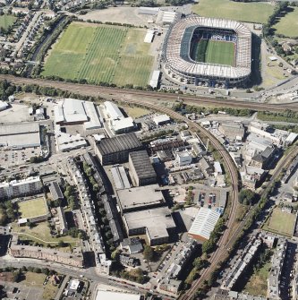 Oblique aerial view centred on the bonded warehouse with the park and bowling green and stadium adjacent, taken from the SSE.