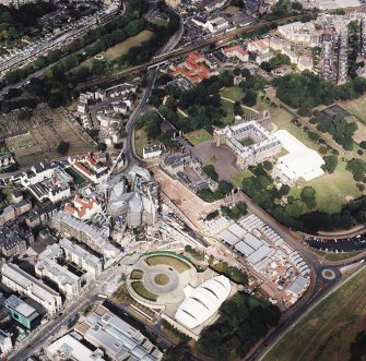 Oblique aerial view centred on the construction of the Scottish Parliament with Our Dynamic Earth, Queensbury House and Holyrood Palace adjacent, taken from the SW.