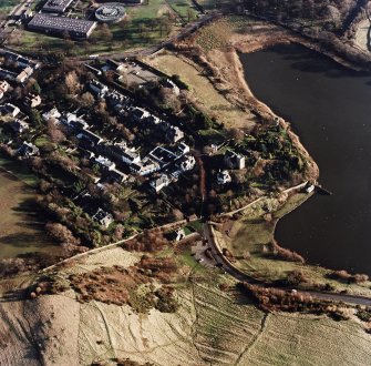 Oblique aerial view of Edinburgh centred on Duddingston Village with the parish church and south lodge visible, taken from the NW.