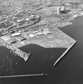 Oblique aerial view centred on the industrial estate with the office, works, harbour, and gas works adjacent, taken from the ENE.
