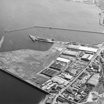 Oblique aerial view centred on the industrial estate with the harbour adjacent, taken from the W.