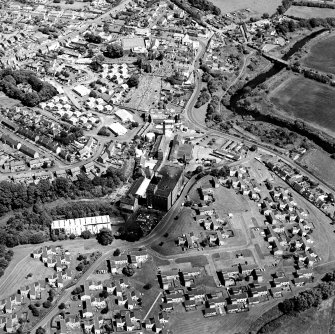 Oblique aerial view of former distillery, taken from SW, with Saladin-box maltings to centre right and floor-maltings with two kilns to centre left