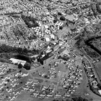 Oblique aerial view of former distillery, taken from S, with Saladin-box maltings in the foreground left.