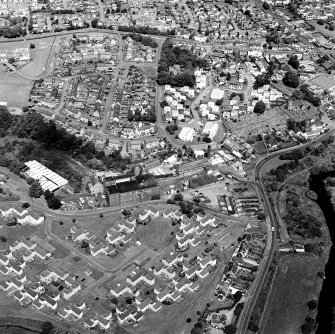 Oblique aerial view of former distillery, taken from S, with Saladin-box maltings in the foreground left.