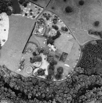 Oblique aerial view of Dunglass centred on a church and stables, taken from the SE.