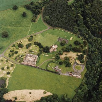 Oblique aerial view of Dunglass centred on the Collegiate Church with Dunglass House stables adjacent, taken from the SW.